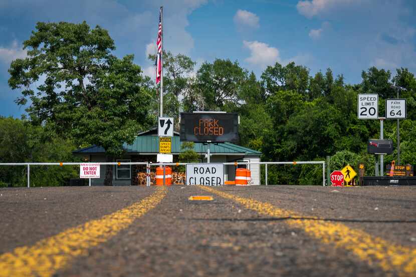 Signs mark the park closed at the locked gate of Fairfield Lake State Park on Monday, June...