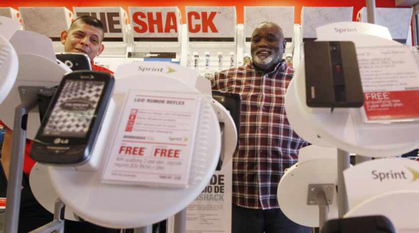 Manager Ruben Zarate (left) helps customer Melvin Cheatham  select a smartphone at the...