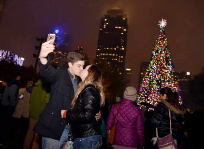 Un beso y selfie, con árbol y centro de Dallas incluido. La foto perfecta.