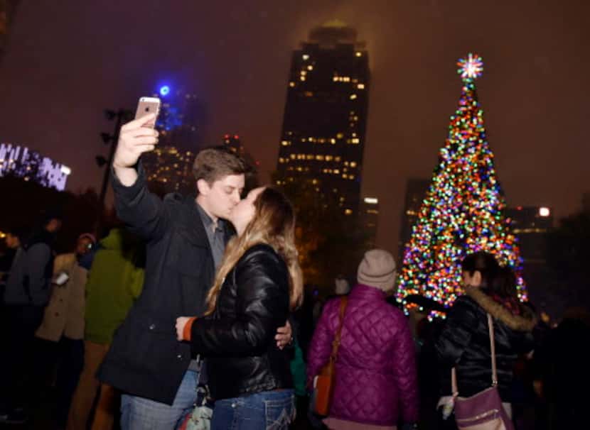 Un beso y selfie, con árbol y centro de Dallas incluido. La foto perfecta.