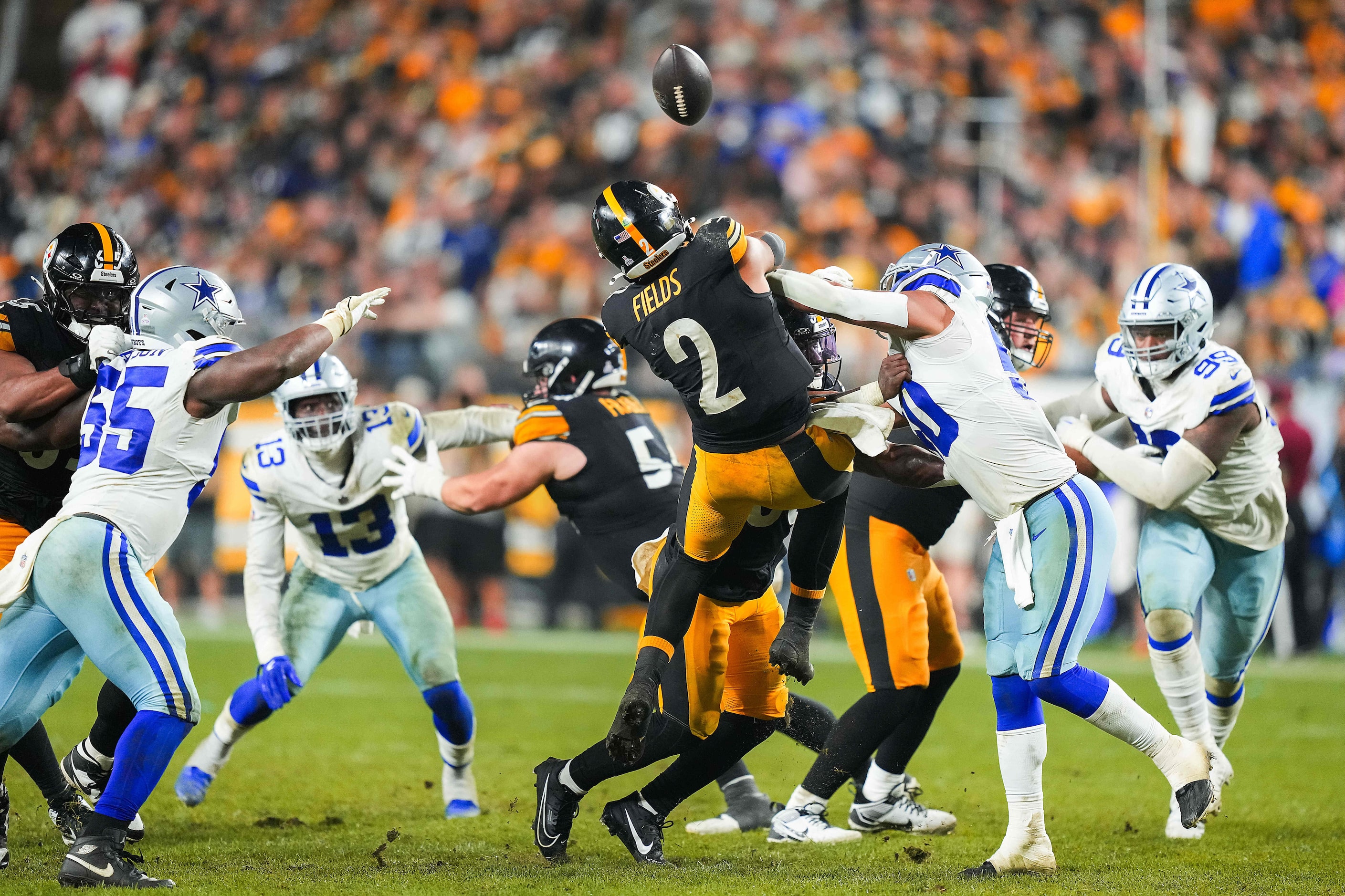 Pittsburgh Steelers quarterback Justin Fields (2) gets off an incomplete pass as he is hit...