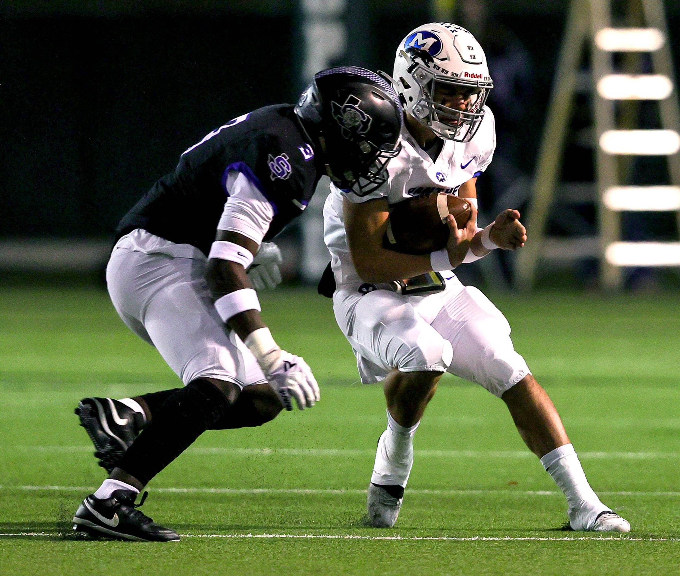 Midlothian quarterback Chad Ragle (r) tries to scramble away from Mansfield Summit defensive...