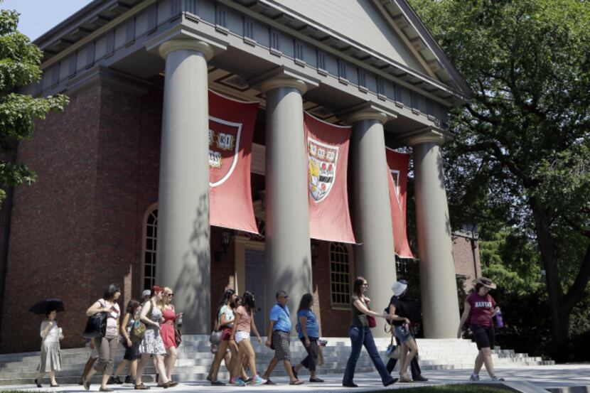 People are led on a tour on the campus of Harvard University in Cambridge, Mass. According...
