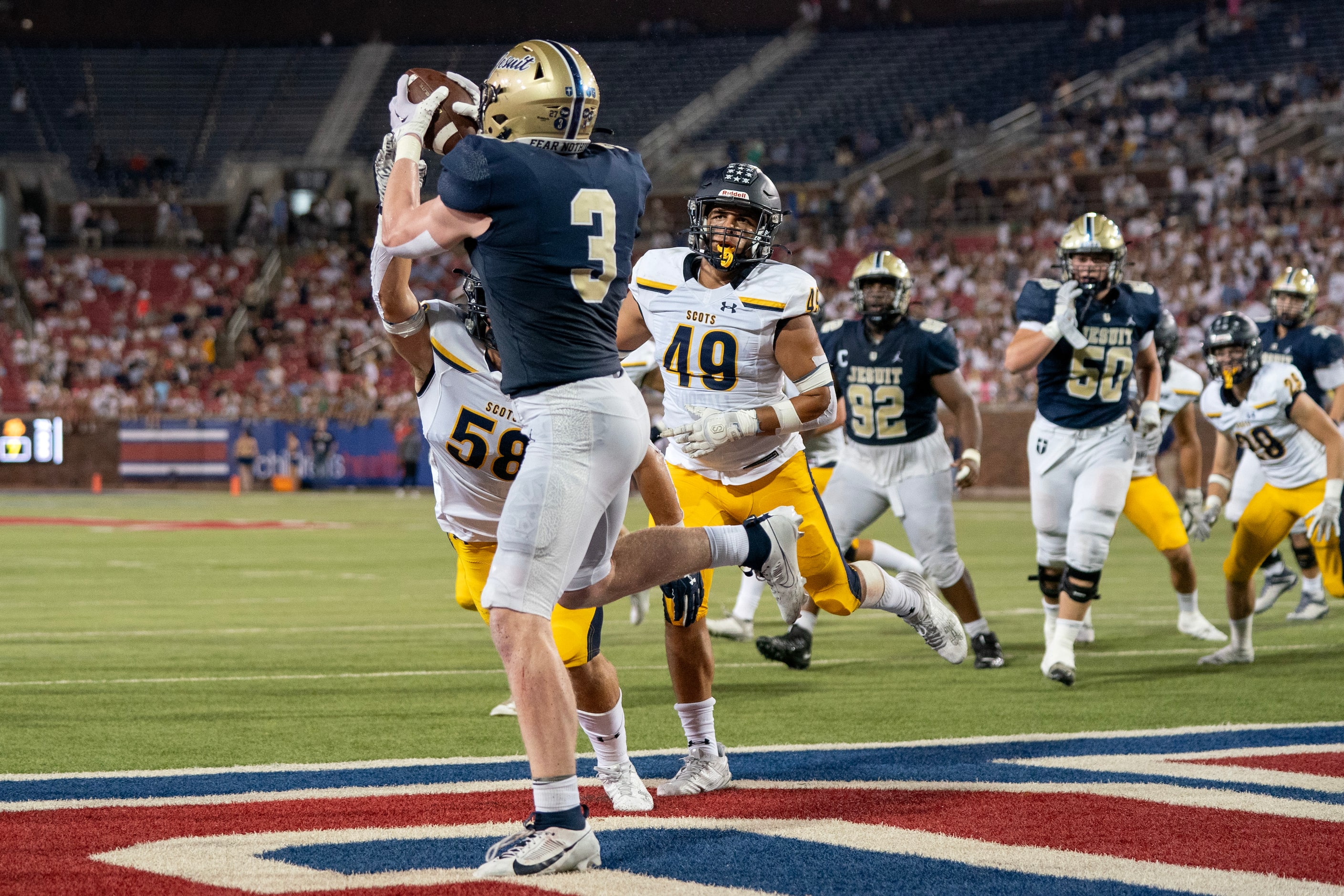 Jesuit junior offensive lineman Cade Gill (3) hauls in a touchdown pass in front of Highland...