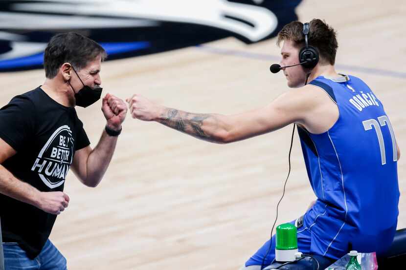 Mavericks owner Mark Cuban fist bumps guard Luka Doncic (77) after a 118-117 win against the...