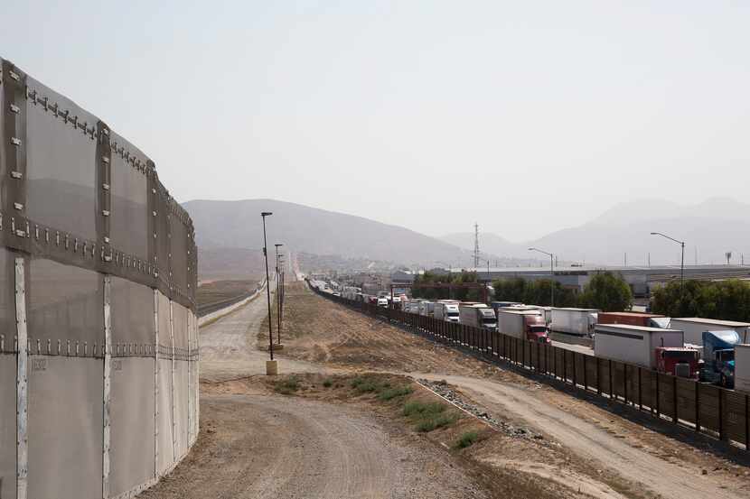 A long line of trucks coming from Tijuana, Mexico, enter the U.S., on the south end of San...