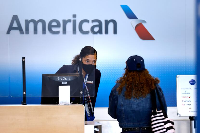 An American Airlines customer assistance representative checks-in a passenger in Terminal A...