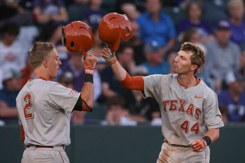 Texas' Kody Clemens (2) taps helmets with Austin Todd (44) after a home run in the third...
