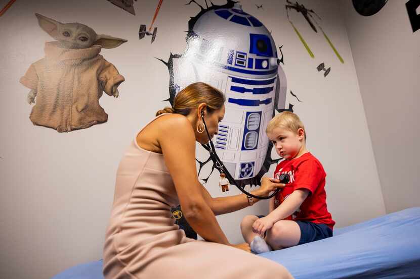 Dr. Diana Castro (left) checks Hudson Sanford’s, a young boy with Duchenne muscular...