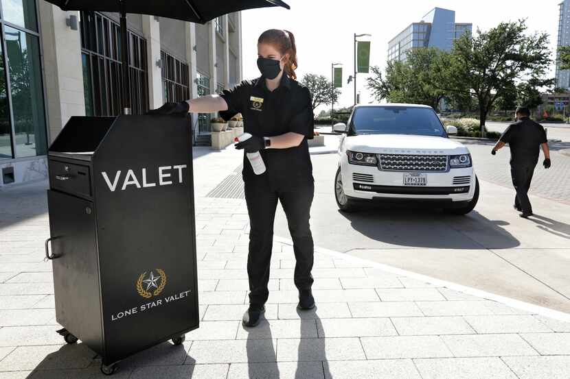 Allison Cole, left, cleans the valet booth while Gabe Munoz walks to a car at Legacy West in...