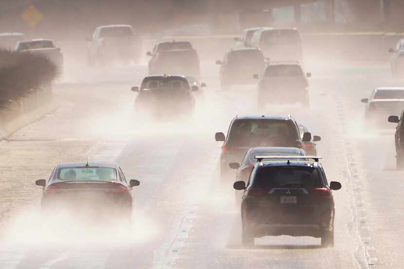 Water sprays from melting roads as traffic head south on US-75, Central Expressway, near...