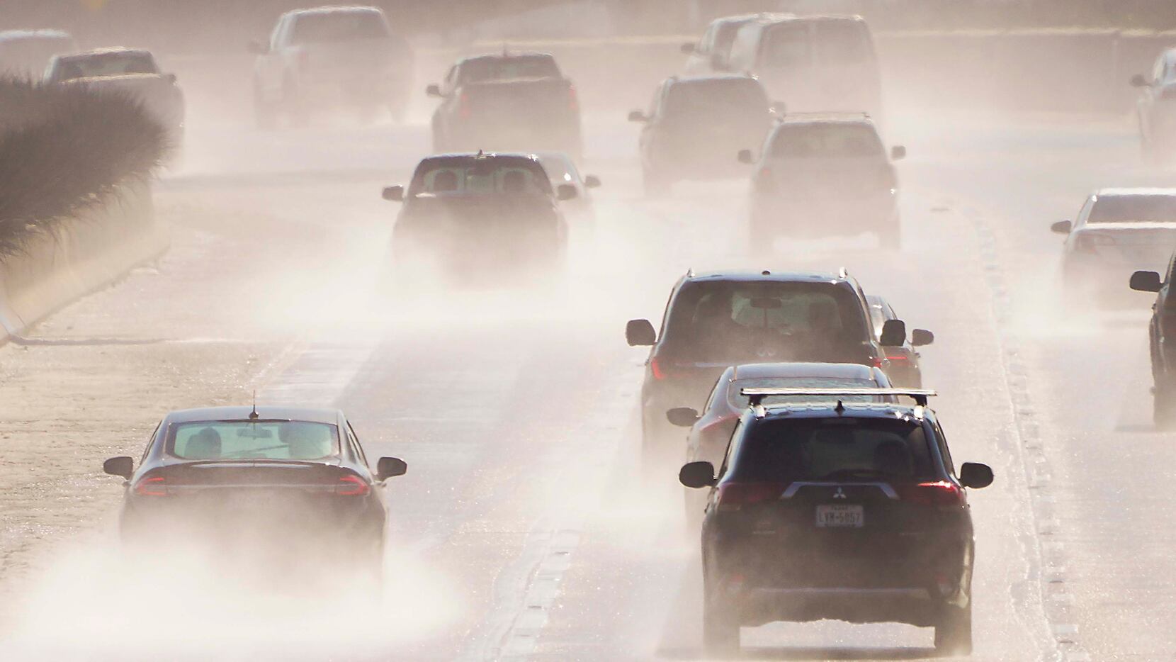 Water sprays from melting roads as traffic head south on US-75, Central Expressway, near...