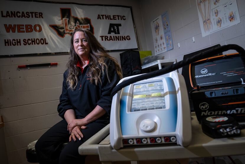 Jordan Hart, head athletic trainer for Lancaster High School, sits next to an ultra sound...