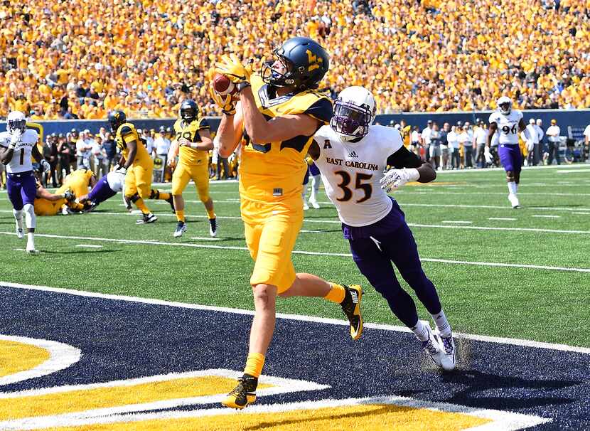 FILE - West Virginia's David Sills V (13) makes a touchdown catch in front of East...