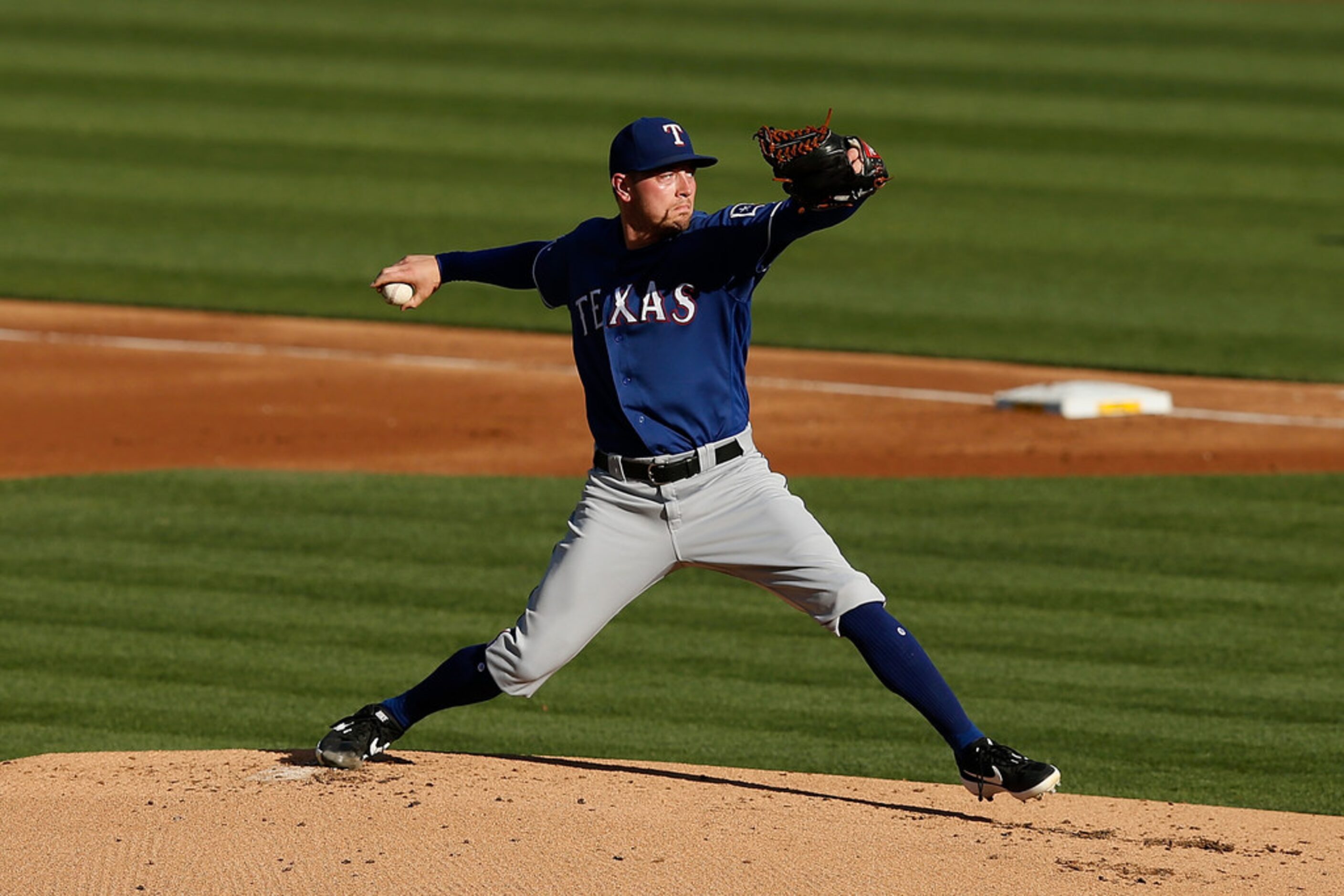 OAKLAND, CALIFORNIA - JULY 27: Adrian Sampson #52 of the Texas Rangers pitches in the bottom...