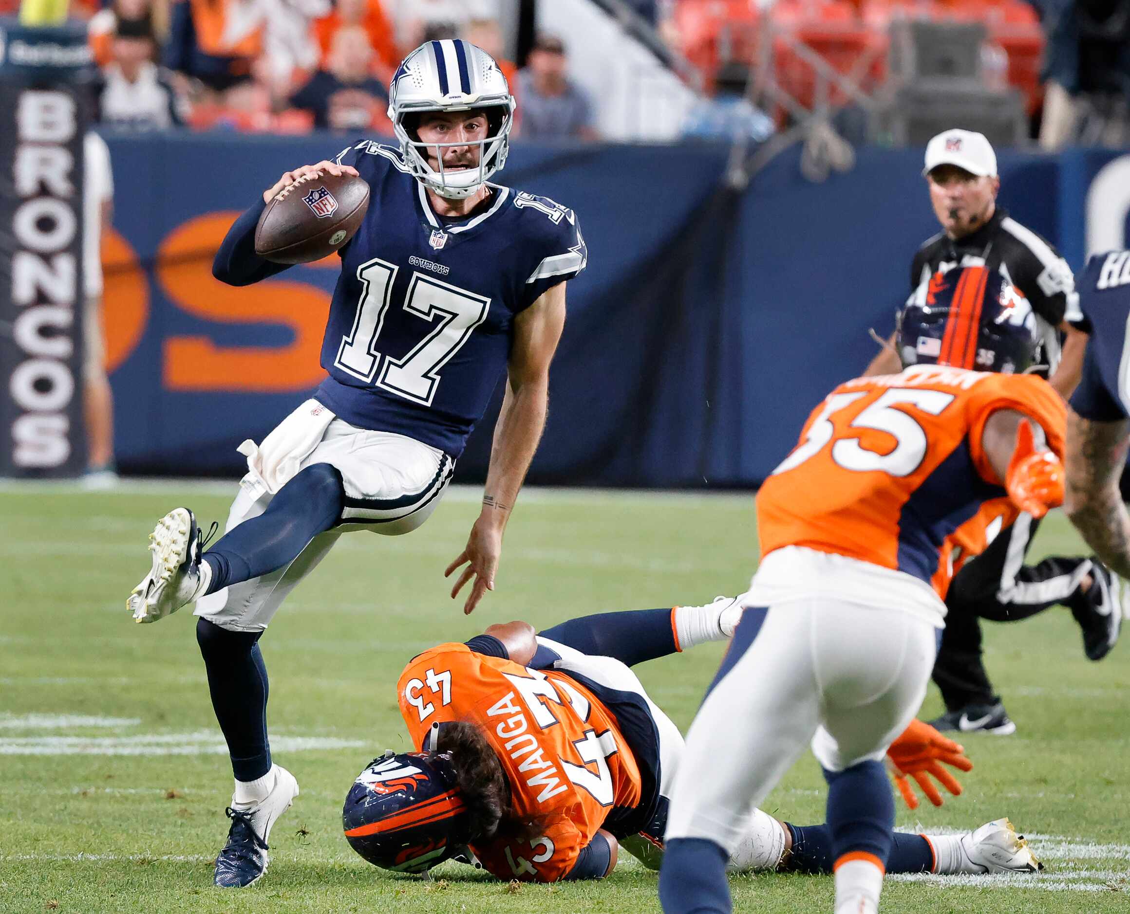 Dallas Cowboys quarterback Ben DiNucci (17) escapes he grasp of Denver Broncos linebacker...