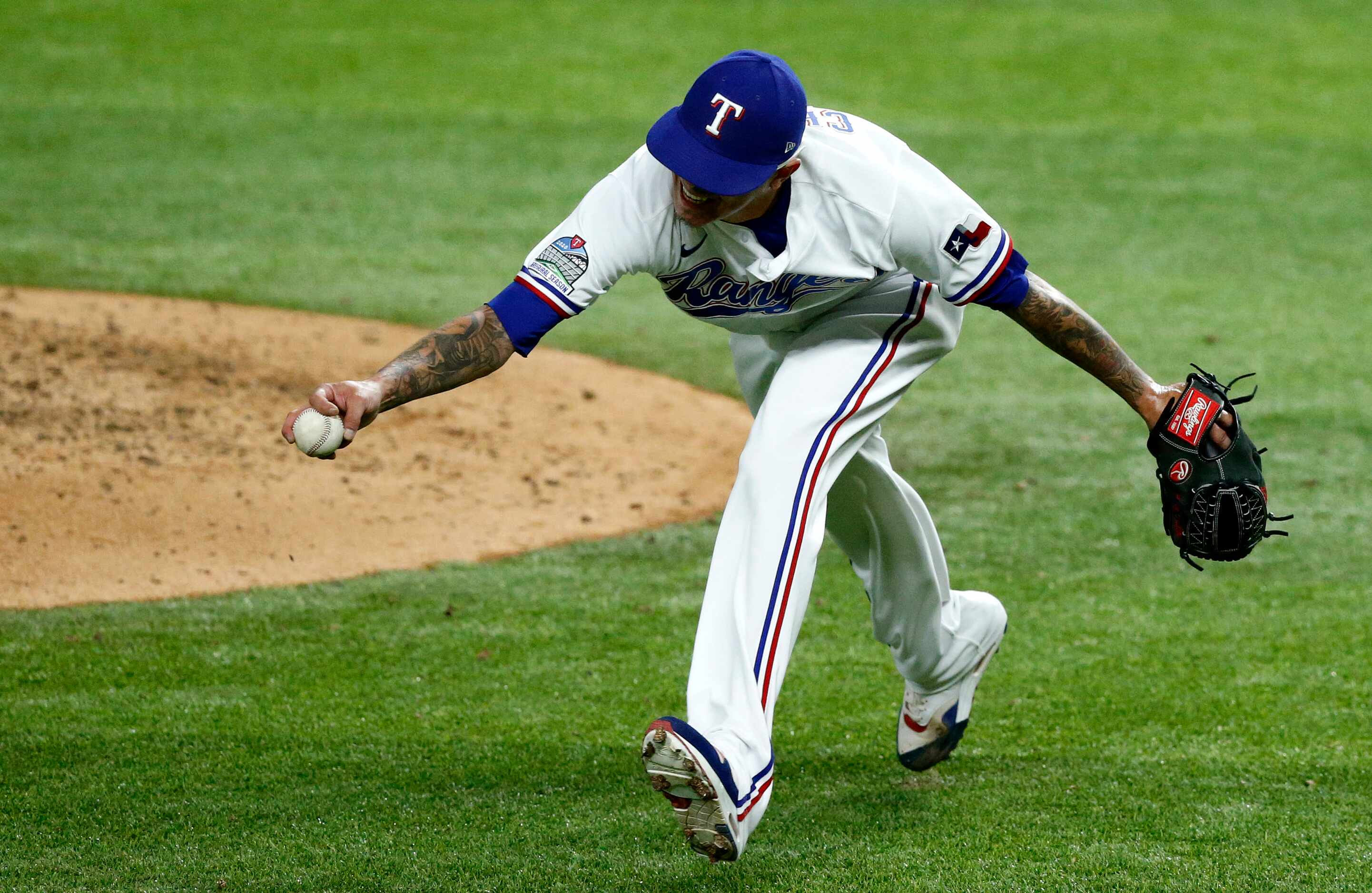 Texas Rangers relief pitcher Jesse Chavez (30) fields an infield hit by San Diego Padres...
