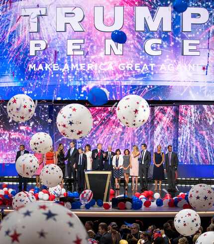 Donald Trump and Mike Pence celebrate with their families as balloons drop on the final...