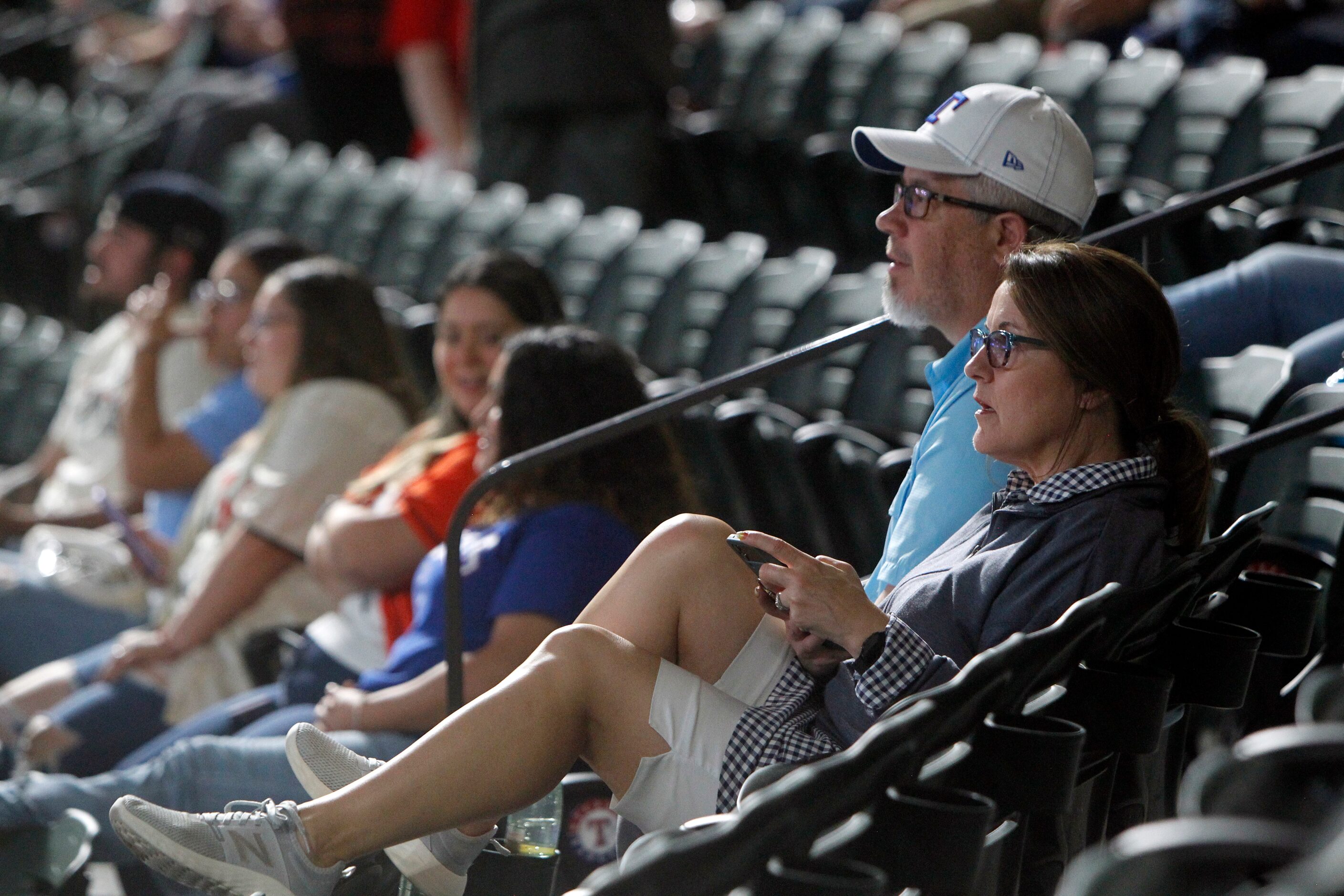 Texas Rangers fans Scotty and Chandelle Gage, of Northlake, relax before the starting lineup...