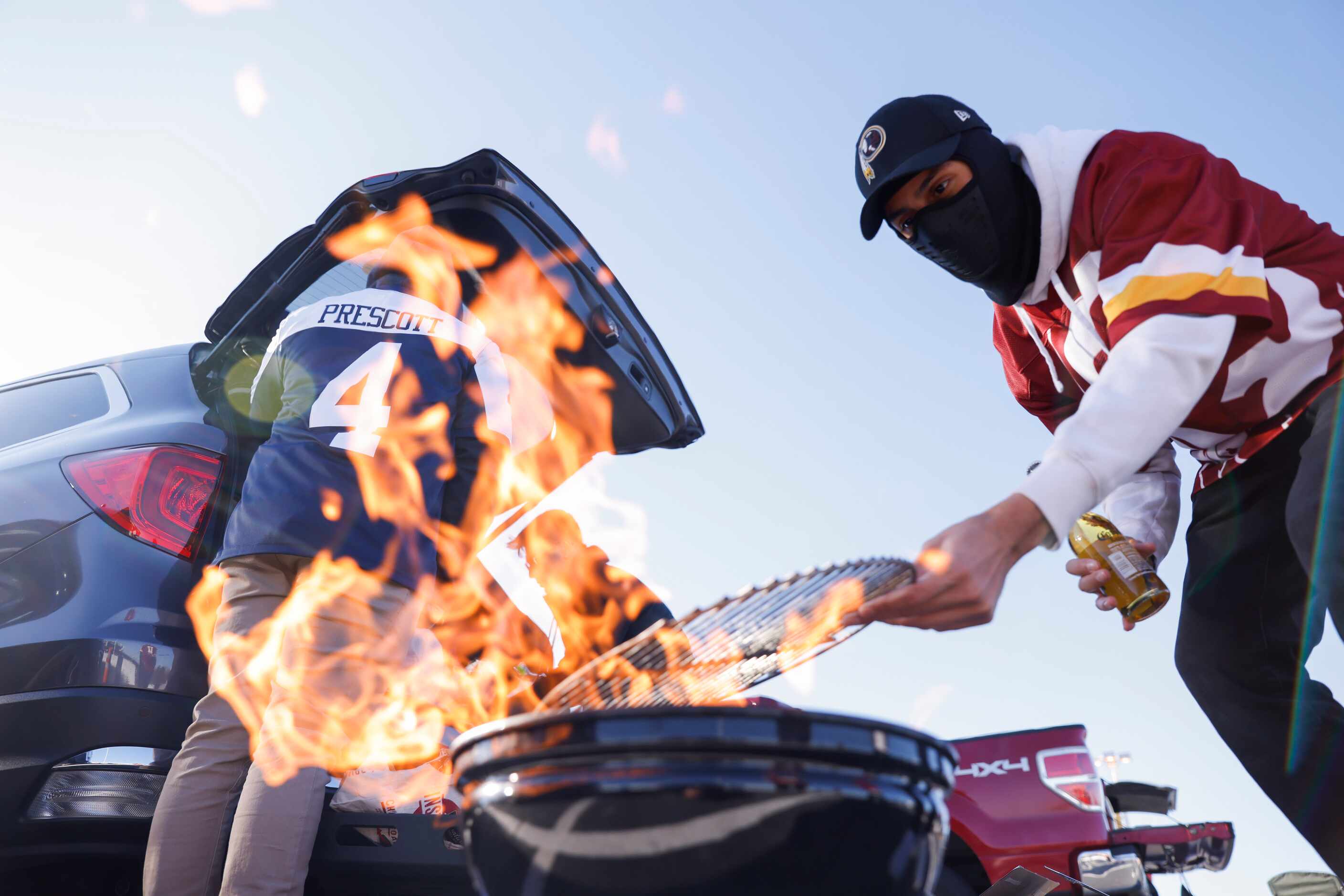 Washington Football Team fan Chris Vasquez of Fairfax, VA gets the grill ready before the...