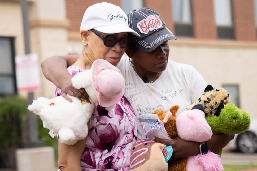Francine Howard (left) of McKinney is comforted by Cheryl Jackson at a memorial set up...