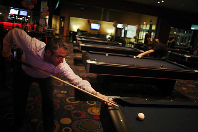 Darin Lyons lines up a shot while playing pool at Main Event in Frisco. Today's...