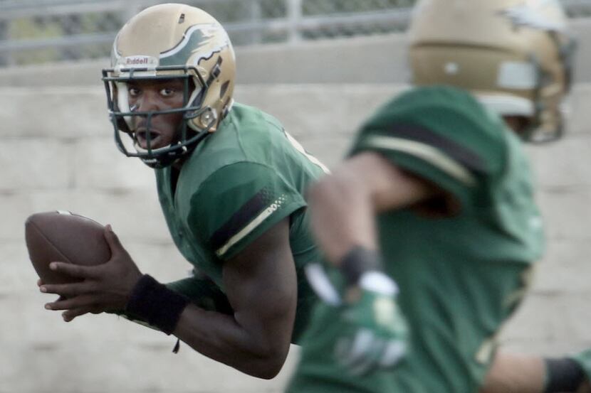 DeSoto Eagles quarterback Tristen Wallace (5) rolls out in search of a receiver during...