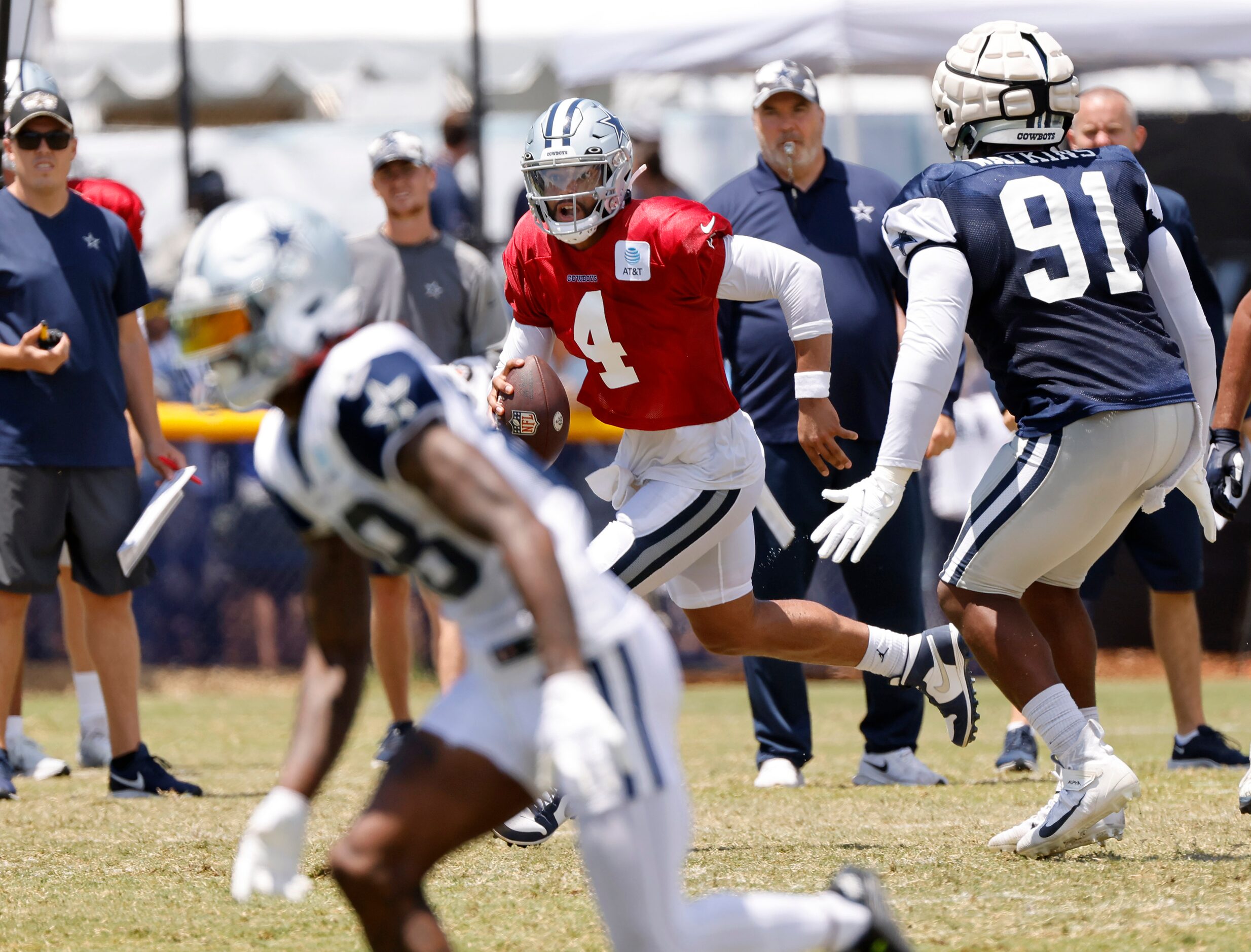 Dallas Cowboys quarterback Dak Prescott (4) rolls out looking for a receiver as he’s pursued...