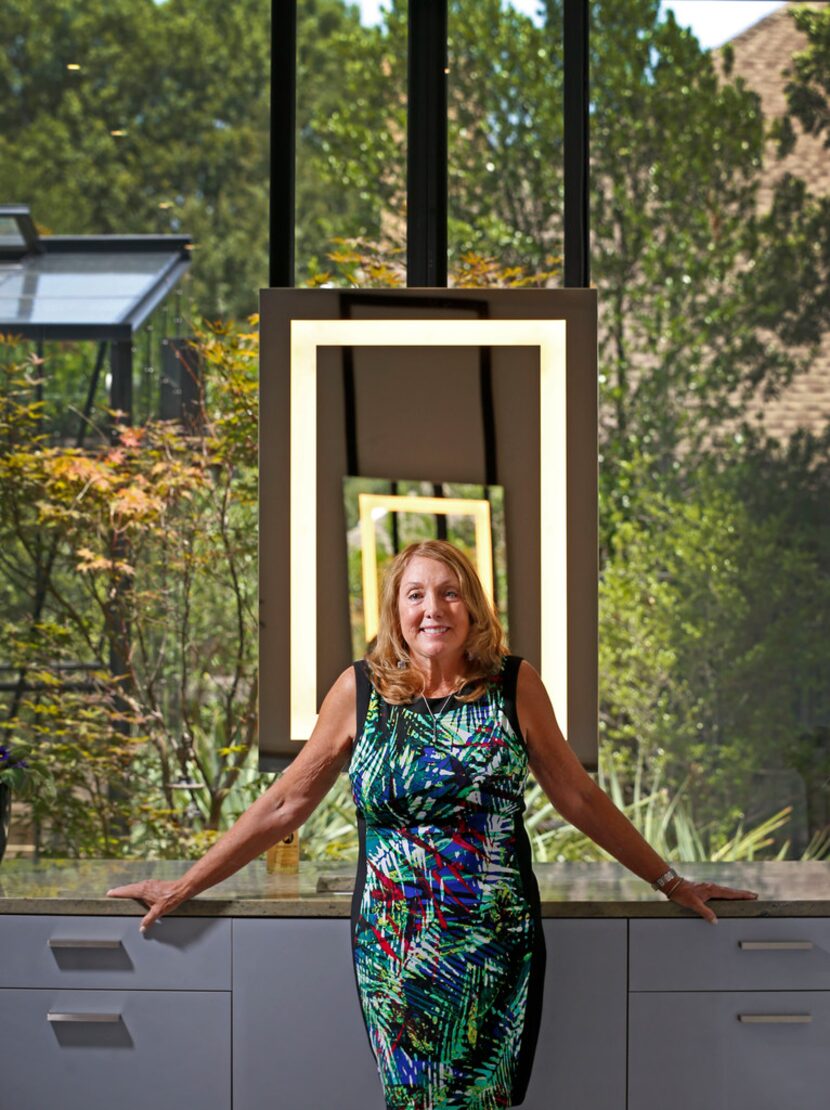 Homeowner Lynn Rush poses for a photograph in front of a mirror with a LED light in the...