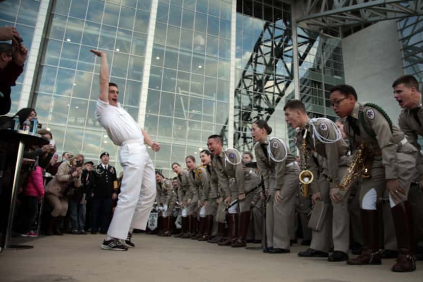 Texas A&M yell leader Ryan Crawford fired up the band and Aggie fans in the plaza of Cowboys...