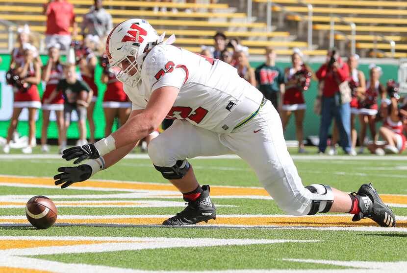 The Woodlands offensive lineman McKade Mettauer (72) recovers a fumbled ball in the end zone...