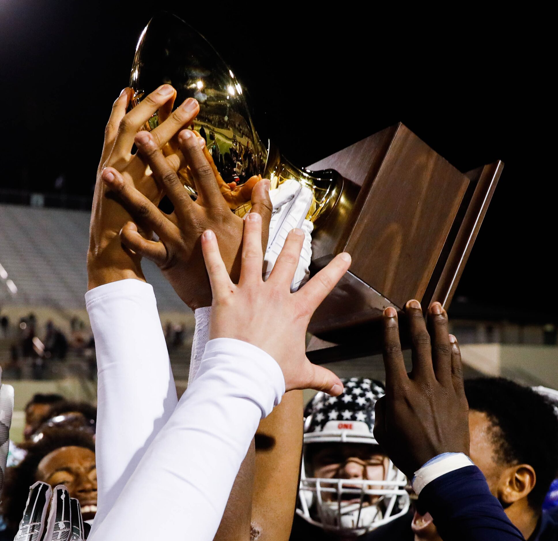 Denton Ryan football players celebrate winning the District 5-5A Division I title against...