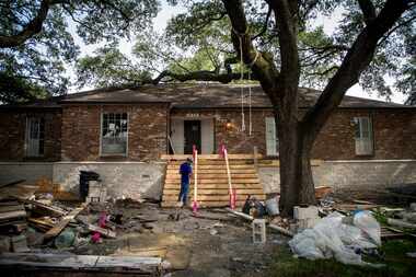 Workers erect a new front stairs for a house in the 4900 block of Braesvalley Drive, that...