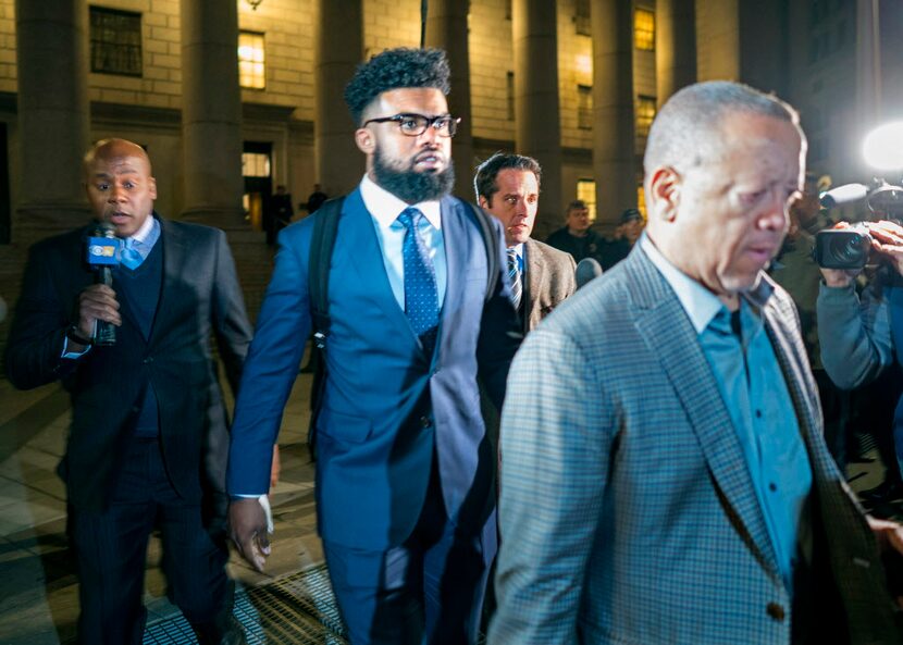 Dallas Cowboys star Ezekiel Elliott, center, exits federal court after a hearing Monday,...