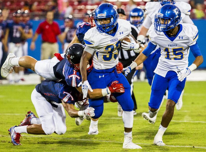 Frisco fullback Idrees Ali (33) is tackled by Frisco Centennial defensive back Raleigh...