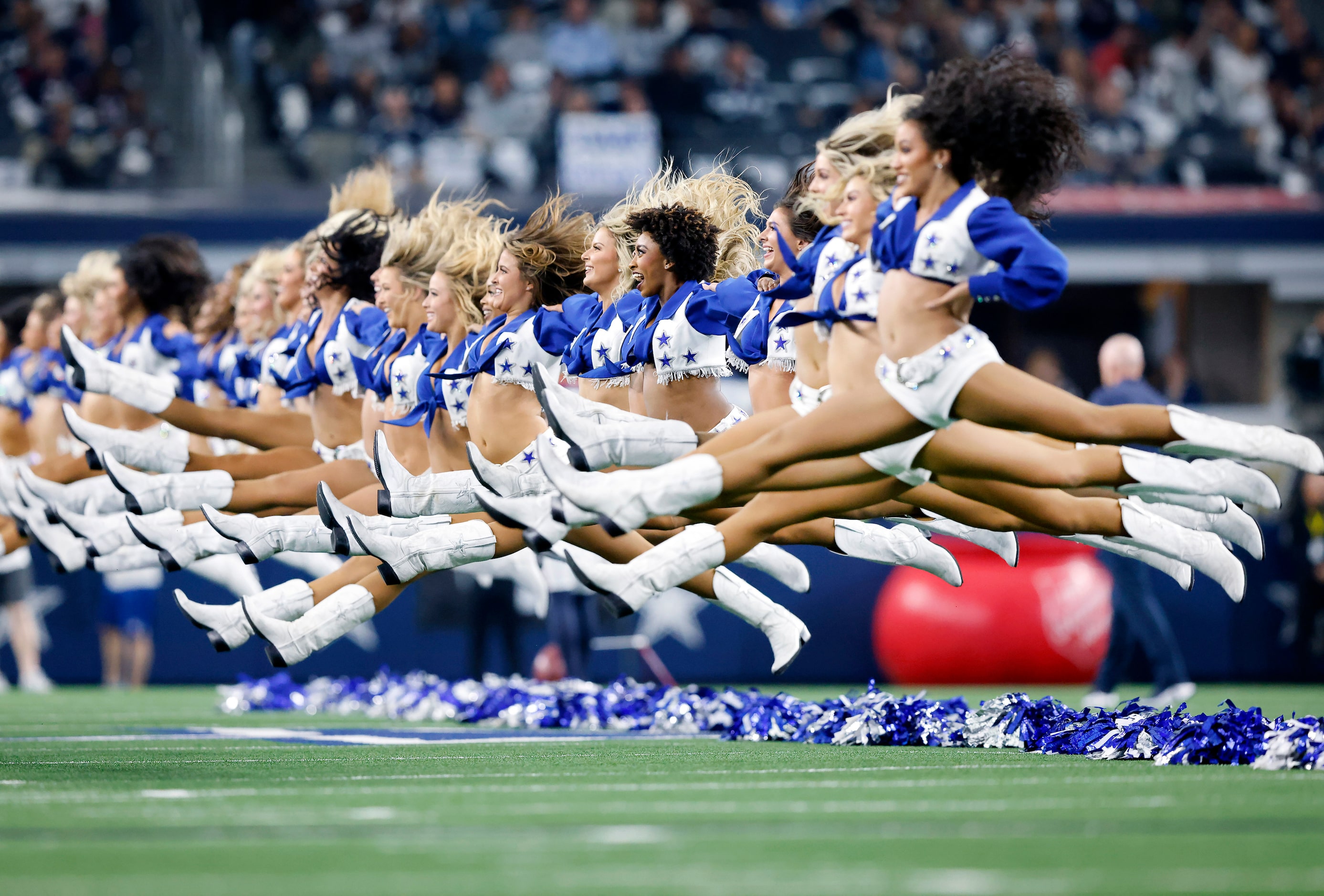 The Dallas Cowboys Cheerleaders jump into the splits at the end of their pregame performance...