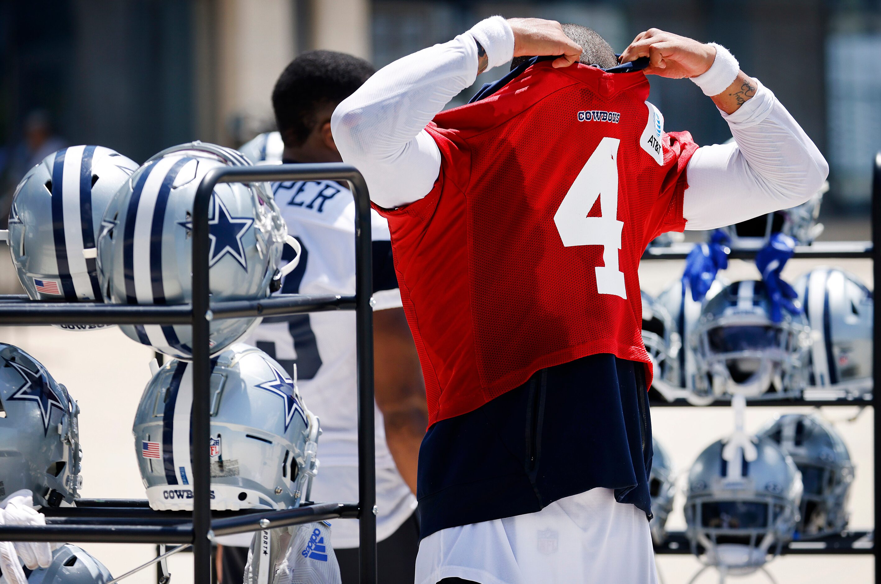 Dallas Cowboys quarterback Dak Prescott (4) pulls off his jersey and pads following Training...