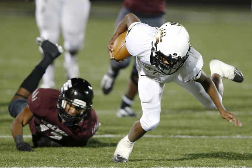 South Oak Cliff's Cedric Tatum (28) is tripped up by  Mansfield Timberview's Tre Davis (12)...