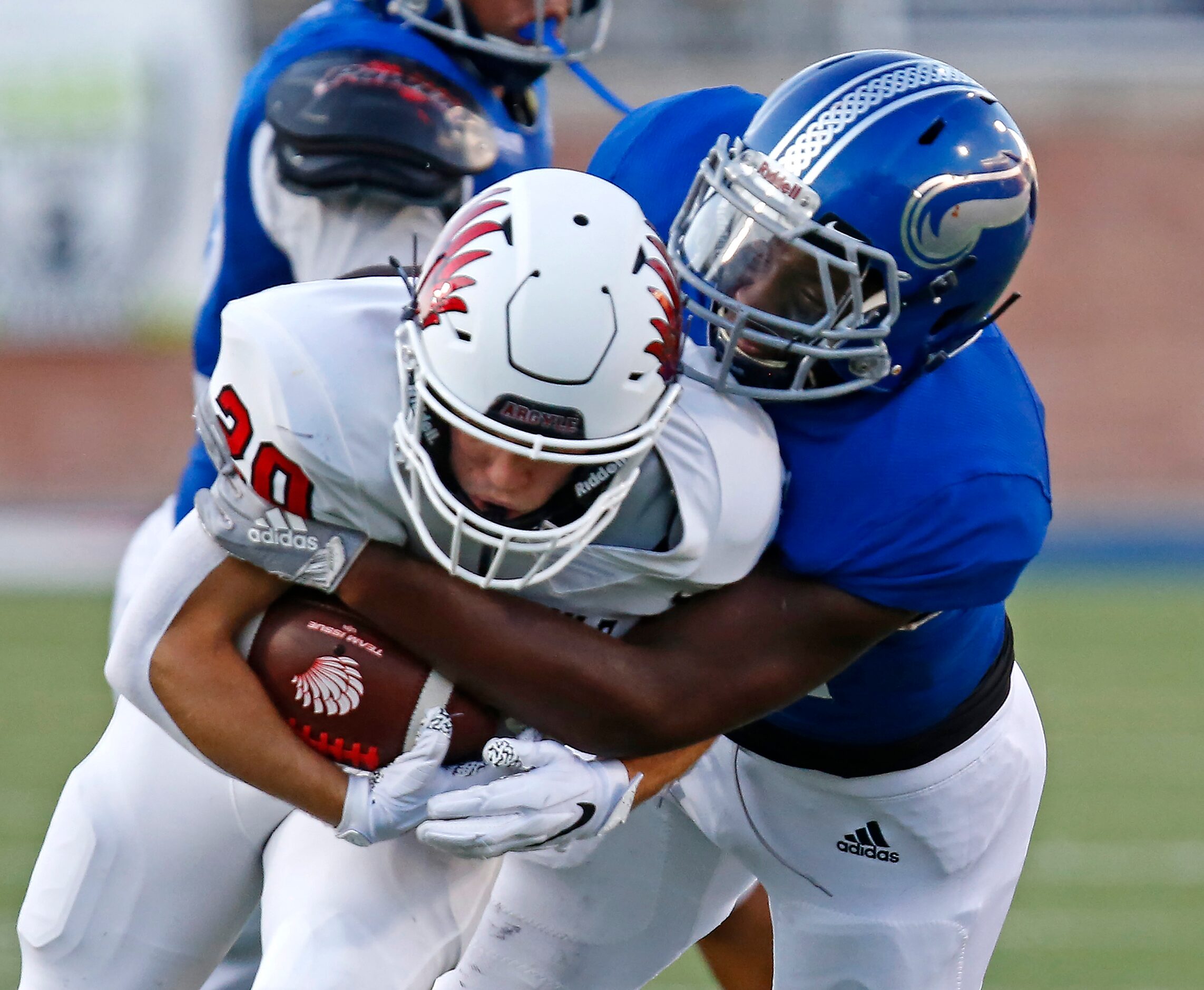 Nolan Catholic High School middle linebacker T.K. Woodson (44) tackles Argyle High School...