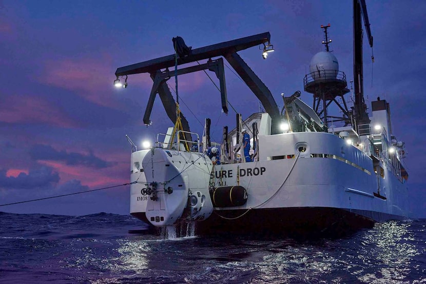 The submersible craft Limiting Factor returns to the surface and is lifted by the ship DSSV...