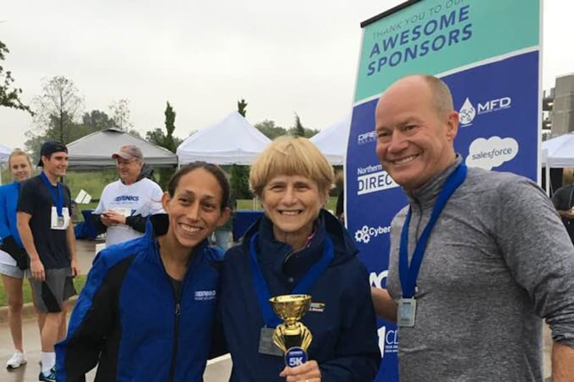 Kim Andres of Irving receives her trophy for first in her age group at Saturday's Brinks...