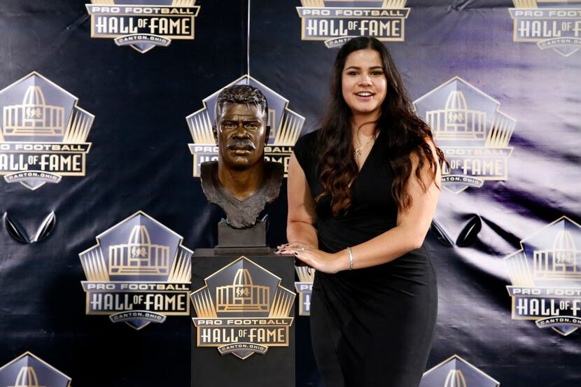 Daughter of former NFL player Junior Seau, Sydney Seau poses with a bust of her father...