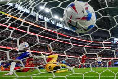 A shot by Folarin Balogun of the United States, left, enters the net of Bolivia goalkeeper...