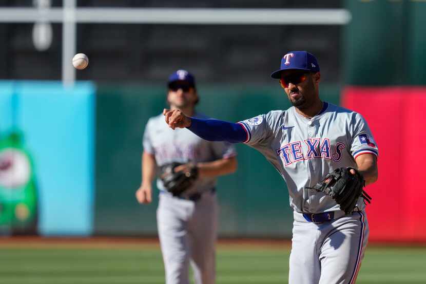 Texas Rangers second baseman Marcus Semien throws to first base for the out on Oakland...