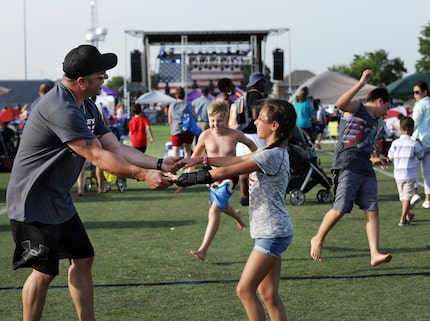 Ted Paulmeno and 11-year-old Adriana Paulmeno dance to music during the Allen USA...