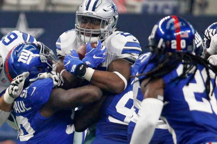 Dallas Cowboys running back Ezekiel Elliott (21) struggles for yardage in the first quarter...