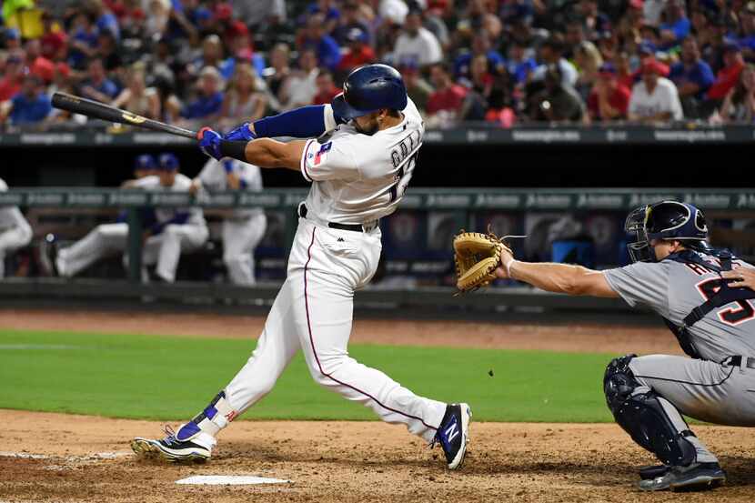 Texas Rangers third baseman Joey Gallo (13) follows through on a two-run homer in front of...