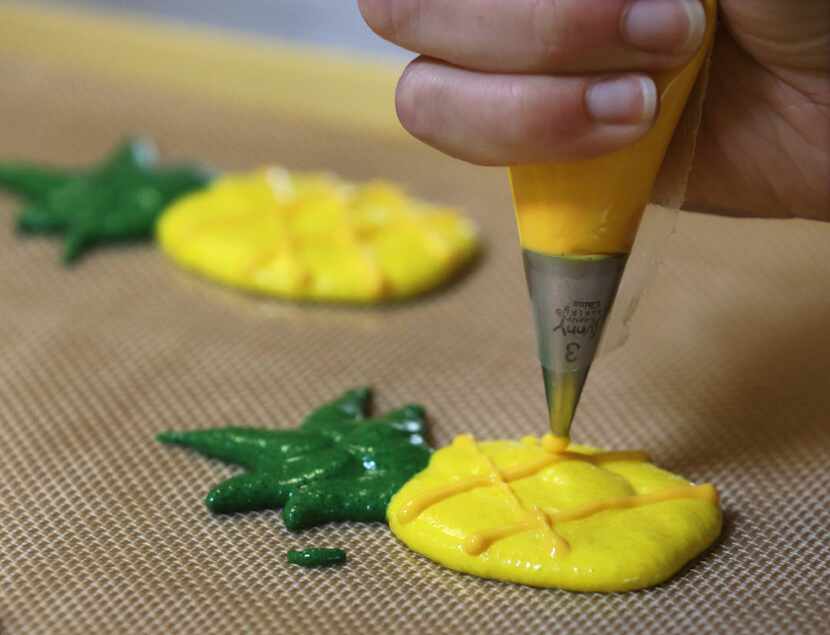 Baker Kelcie Feldotto first piped the pineapple macarons onto a reusable baking mat using...