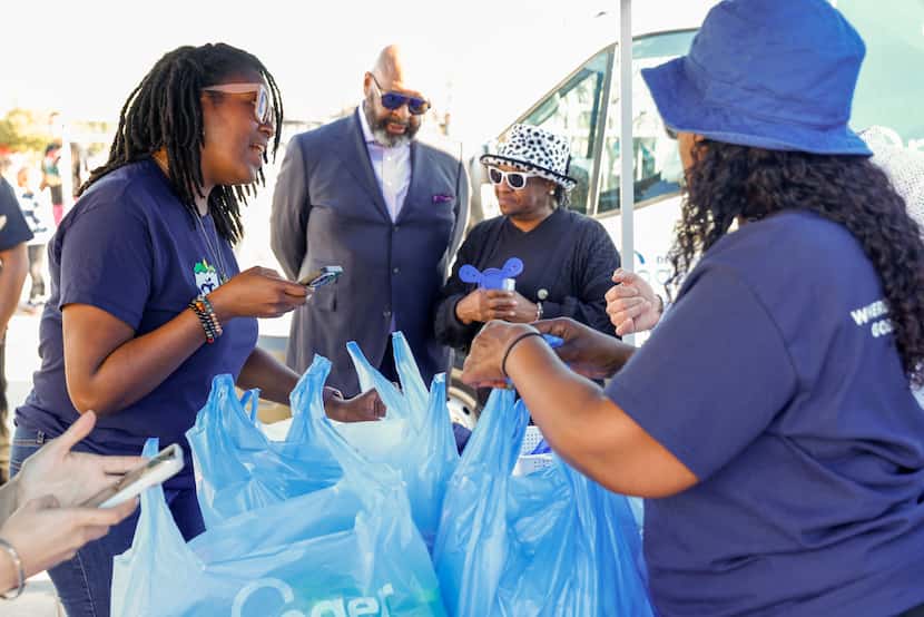 Kendra C. Smith (left) picks up her groceries from Kroger during an event for the launch of...