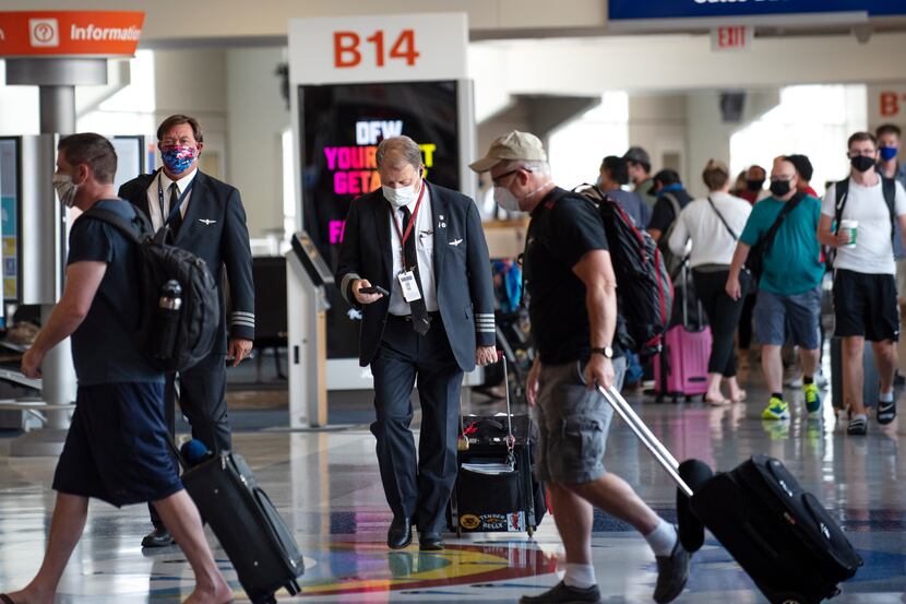 American Airlines pilots walk through Terminal B at DFW International Airport. The airline...